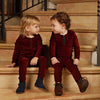 Adorable baby in a burgundy red chenille soft set, warm matching sibling style for cozy family gatherings.
