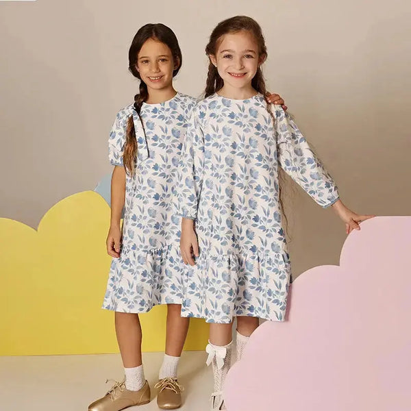 Little lady wearing a blue bloom Shabbos set, elegant matching sister outfit for special Shabbat dinners.