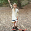 Young girl in a letter A navy stripes set, coordinated matching sister outfit for family celebrations.