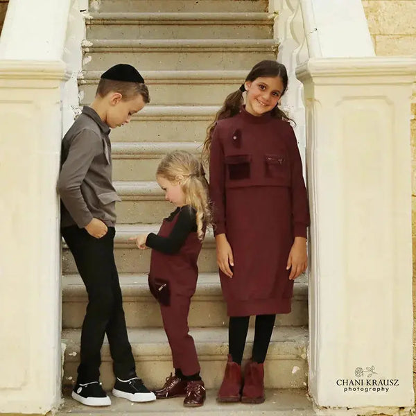 Young girl wearing an irregular pocket unique set, modern matching sister style for contemporary family looks.