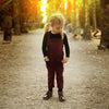 Baby in an irregular pocket design set, distinctive matching sibling style for contemporary family celebrations.