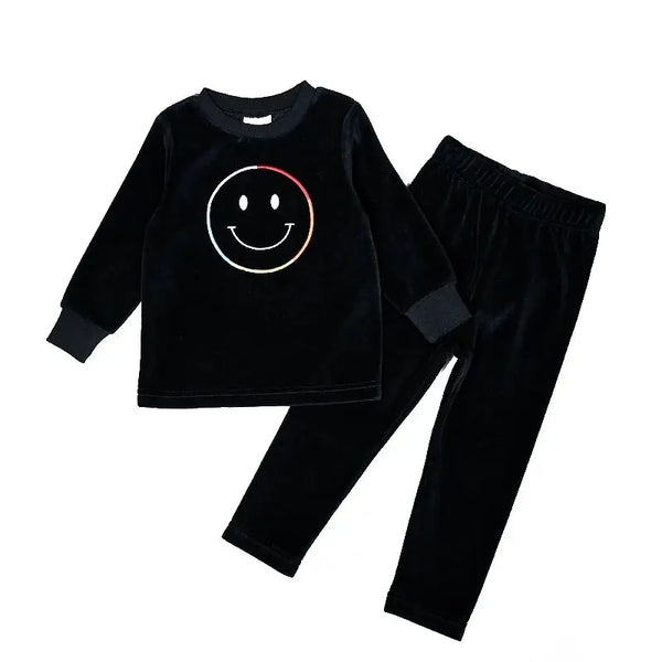 Child in a casual velour smile embroidery set, playful matching outfit for joyful family moments.
