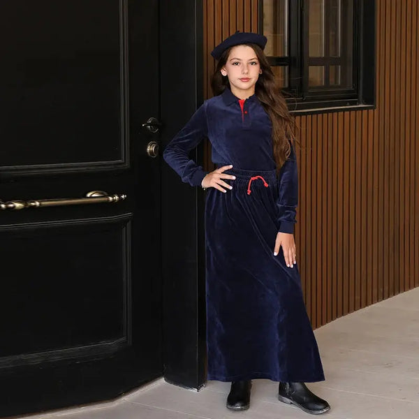 Young girl dressed in a luxury navy velour soft set, plush matching sister style for elegant family occasions.