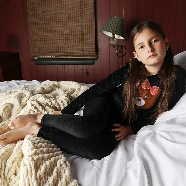 Young girl in a snuggle bear velour soft set, cuddly matching sister outfit for cozy family moments.