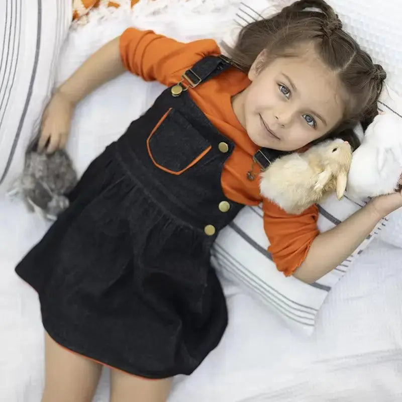 Young girl wearing a black denim classic set, stylish matching sister outfit for casual family outings.